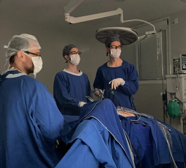 Equipe médica realizando cirurgia laparoscópica em centro cirúrgico