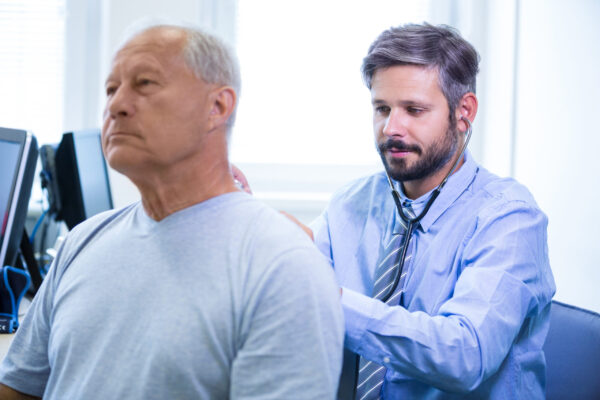 Médico examinando paciente idoso em consulta