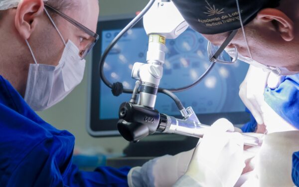 Dr. Fernando Zanchet e equipe em procedimento cirúrgico com microscópio